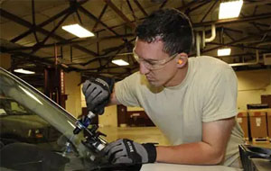 A technician holding a device to fix and repair a Windshield